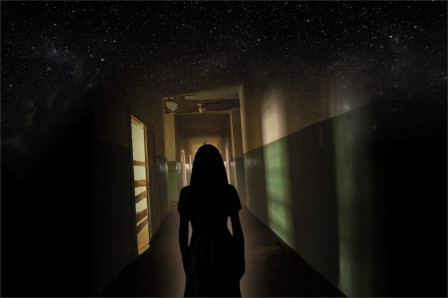Campaign artwork for Bedlam: a silhouetted young woman in a dim hospital corridor beneath a starry sky