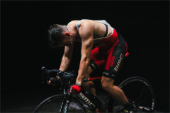Connor Delves hunched over the handlebars of the bike in Cadel: Lungs On Legs at Riverside Studios. Photo by Kyle Dax Smith