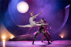 Patricia Zhou as Cassandra in Cats, leaping in a split with members of the company. Photo by Mark Senior