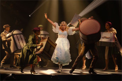 Alice and the company with suitcases in the rabbit-hole sequence of Cirque Alice, from an earlier staging