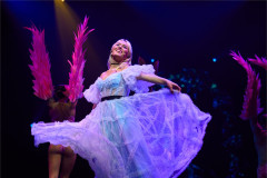 Alice dancing in front of flamingo-feathered performers in Cirque Alice, from an earlier staging