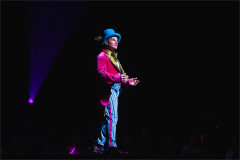 The Mad Hatter in a blue top hat and pink tailcoat in Cirque Alice, from an earlier staging