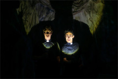 Two of the Crybabies trio lit by torchlight in priests' collars in The Scaring. Photo by Mihaela Bodlovic