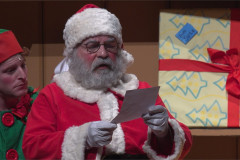 Santa reads a letter as his Elf looks on in Dear Santa. Photo by Norwell Lapley Productions