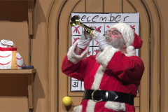 Santa blows a trumpet in his workshop in Dear Santa. Photo by Norwell Lapley Productions