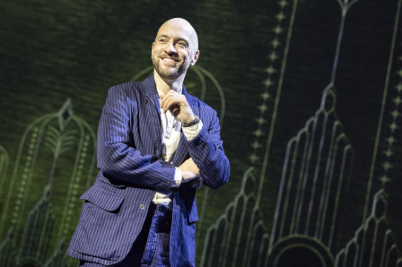 Derren Brown in a pinstripe suit, smiling, on stage in Only Human at the Apollo Theatre