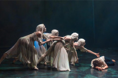 Pale-gowned dancers reach towards a fallen figure in BIG Live's Dracula