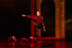 A dancer in crimson leaps through an archway in BIG Live's Dracula