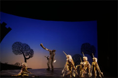 Shinya Matsuda as the Gatekeeper with dancers as unicorns in End of the World and Hard-Boiled Wonderland at the Barbican Theatre