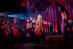 The company and onstage musicians in a red-lit scene in Franz & Marie at Charing Cross Theatre. Photo by Danny Kaan