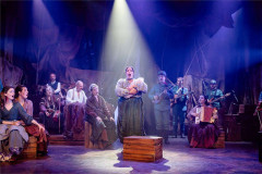 A woman cradles a baby as the company looks on in Franz & Marie at Charing Cross Theatre. Photo by Danny Kaan