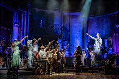 The company of Hadestown raising a toast at the Lyric Theatre, original West End cast. Photo by Marc Brenner