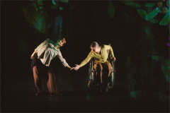 Elvie Rose Christiansen Head bends towards Jen Chandler&rsquo;s outstretched hand on a darkened stage. Photo by Luke Waddington