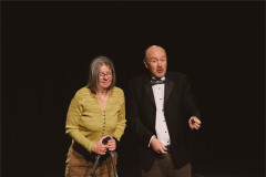 Jen Chandler, on forearm crutches, stands beside James Heather in evening dress. Photo by Luke Waddington
