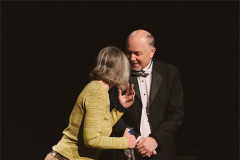 Jen Chandler reaches towards James Heather&rsquo;s face as the two stand close together. Photo by Luke Waddington