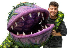 Jed Berry as Seymour held by the Audrey II puppet in rehearsals for Little Shop of Horrors. Photo by Rosie Moore / The Social Sort