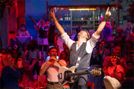 A performance of Mamma Mia! The Party at The O2, with guests dancing at their tables. Photo by Grant Walker