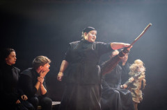 A villager brandishes a broom as the company looks on in Martin Guerre. Photo by Helen Maybanks