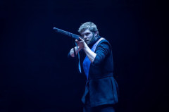 A bearded villager takes aim with a gun in Martin Guerre at the Old Vic. Photo by Helen Maybanks
