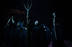 Hooded villagers raise pitchforks and fists in Martin Guerre. Photo by Helen Maybanks