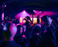 Masked guests beneath pink light at Le Bal Macabre, the Halloween ball staged by Masquerade in New York. Photo by Mark Minton