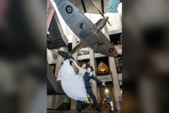 Katrina Lyndon (Cinderella) and Reece Causton (Harry the Pilot) beneath the Spitfire at IWM London. Photo by Craig Sugden