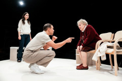 Three members of the cast on the white in-the-round stage of Memoriam at Southwark Playhouse Borough