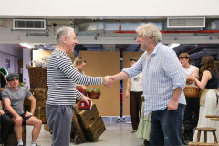 Alan Cumming shakes hands with a fellow cast member in rehearsal for My Fair Lady. Photo by Chris Keatch