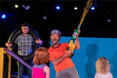 Baffo brandishes a decorated pump while an audience member holds an inner tube in On Your Bike Baffo! Photo by Paul Blakemore