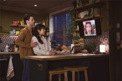 Ty Fanning as James and Ami Okumura Jones as Lou in the kitchen, with Pippa Winslow as Carolanne on a video call, in Paranormal Activity at the Ambassadors Theatre. Photo by Matt Crockett