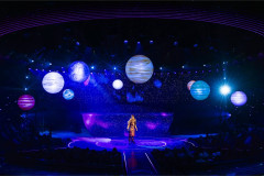 A solo moment beneath a sky of lit planets in Starlight Express at the Troubadour Wembley Park Theatre. Photo by Pamela Raith