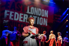 Naomi Katiyo as Sylvia Pankhurst before the East London Federation of Suffragettes banner in Sylvia. Photo by Tristram Kenton