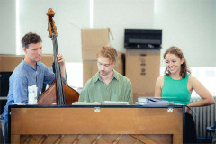 Members of the company of The Pianist rehearsing around the piano. Photo by Rich Southgate