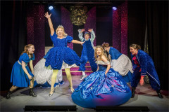 The Tinderella company in blue ball gowns, one arm raised