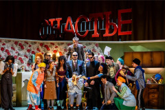 The company packs into the communal flat in To Die For [A Comedy], Nederlandse Reisopera's 2026 Dutch touring production