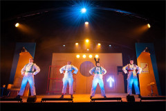 The four-strong company of Toto in white flight suits under the lights at Polka Theatre