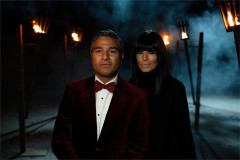 Nick Mohammed and Claudia Winkleman in Traitors costume beside lit torches at Ardross Castle. Photo by Euan Cherry