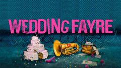 Key art for Wedding Fayre: the title in pink capitals above a toppled wedding cake, a brass horn marked with an anarchy symbol and a spilled HM.GOV briefcase, in front of a razor-wire fence