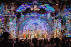 The company of Wicked on stage at the Apollo Victoria Theatre with balloons spelling 14,000,000, seen from the auditorium. Photo by Troy David Johnston