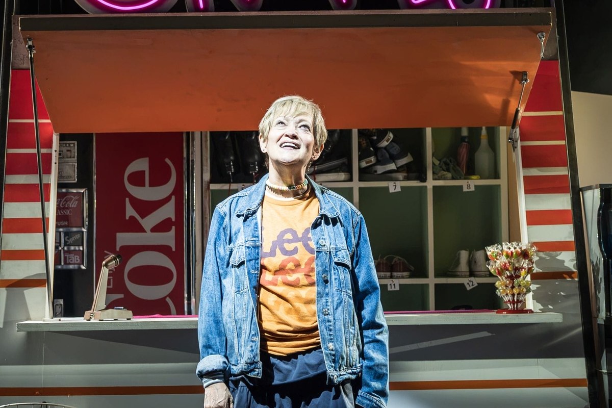 Maria Friedman as Kimberly Levaco outside the skating rink snack bar in Kimberly Akimbo at Hampstead Theatre