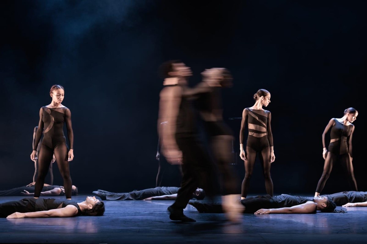Acosta Danza dancers in black on a blue-lit stage in Goyo Montero’s Chacona in Cuban Baroque