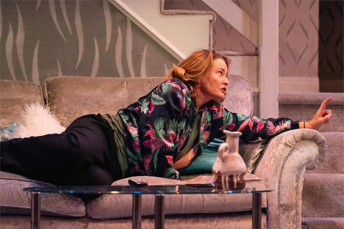 Sarah Belcher as Deborah stretched out on the sofa in All at Sea at Live Theatre, Newcastle. Photo by Von Fox Promotions