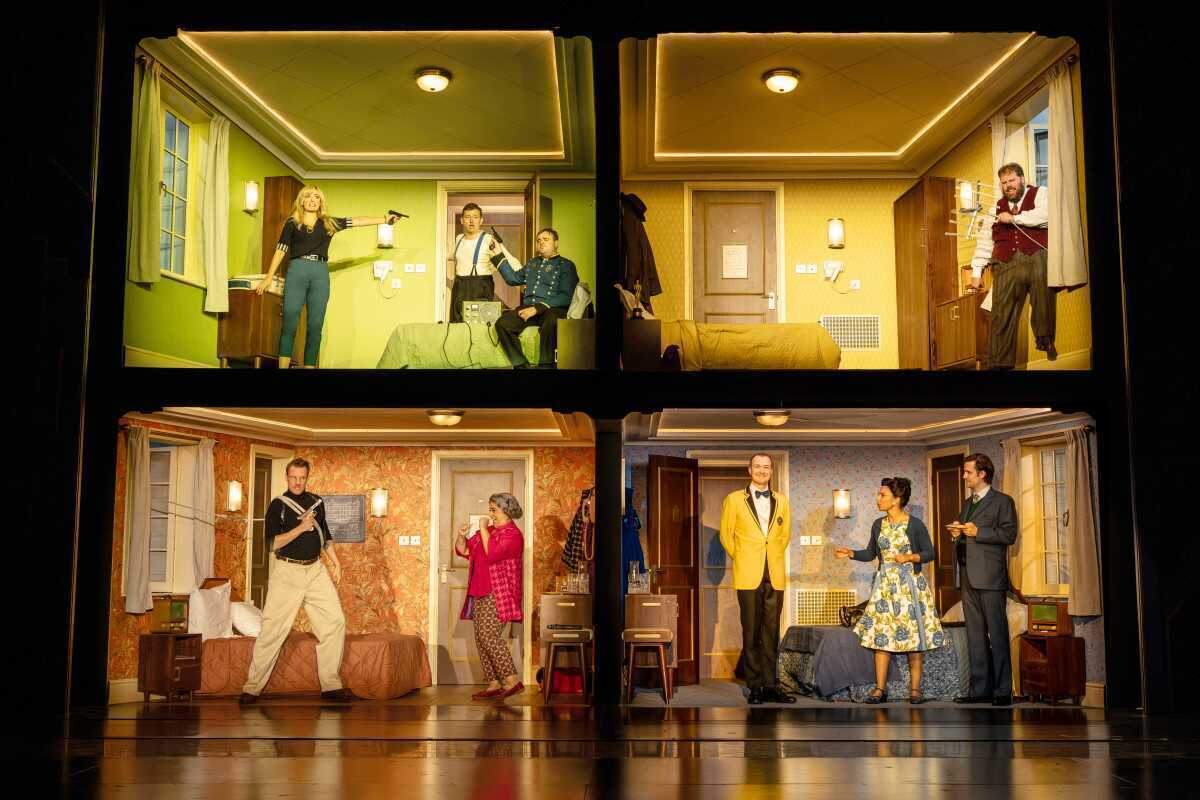 The company of The Comedy About Spies on the four-room hotel set at the Adelphi Theatre