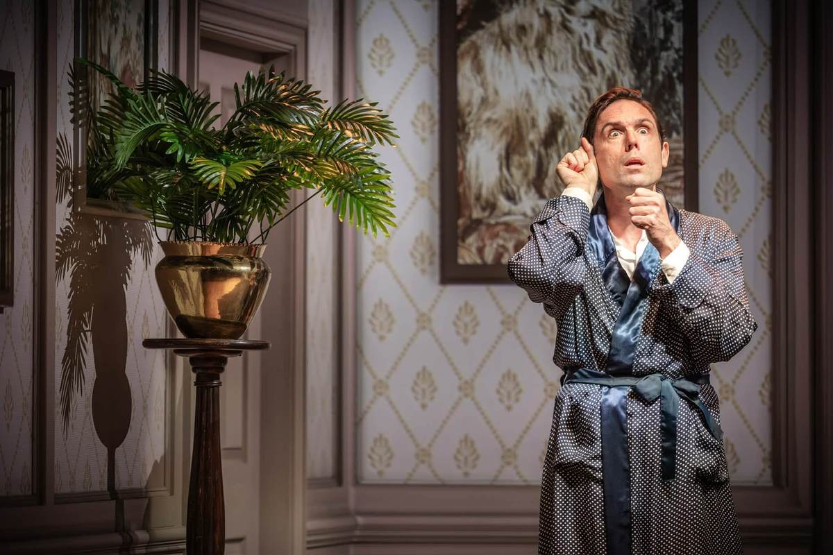 Sam Harrison as Bertie Wooster in a dressing gown in Jeeves Takes Charge at the Charing Cross Theatre