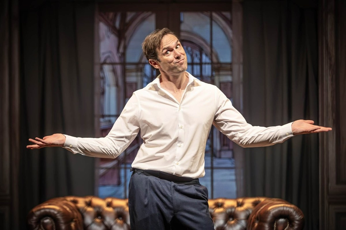 Sam Harrison with arms outstretched in Jeeves Takes Charge at the Charing Cross Theatre