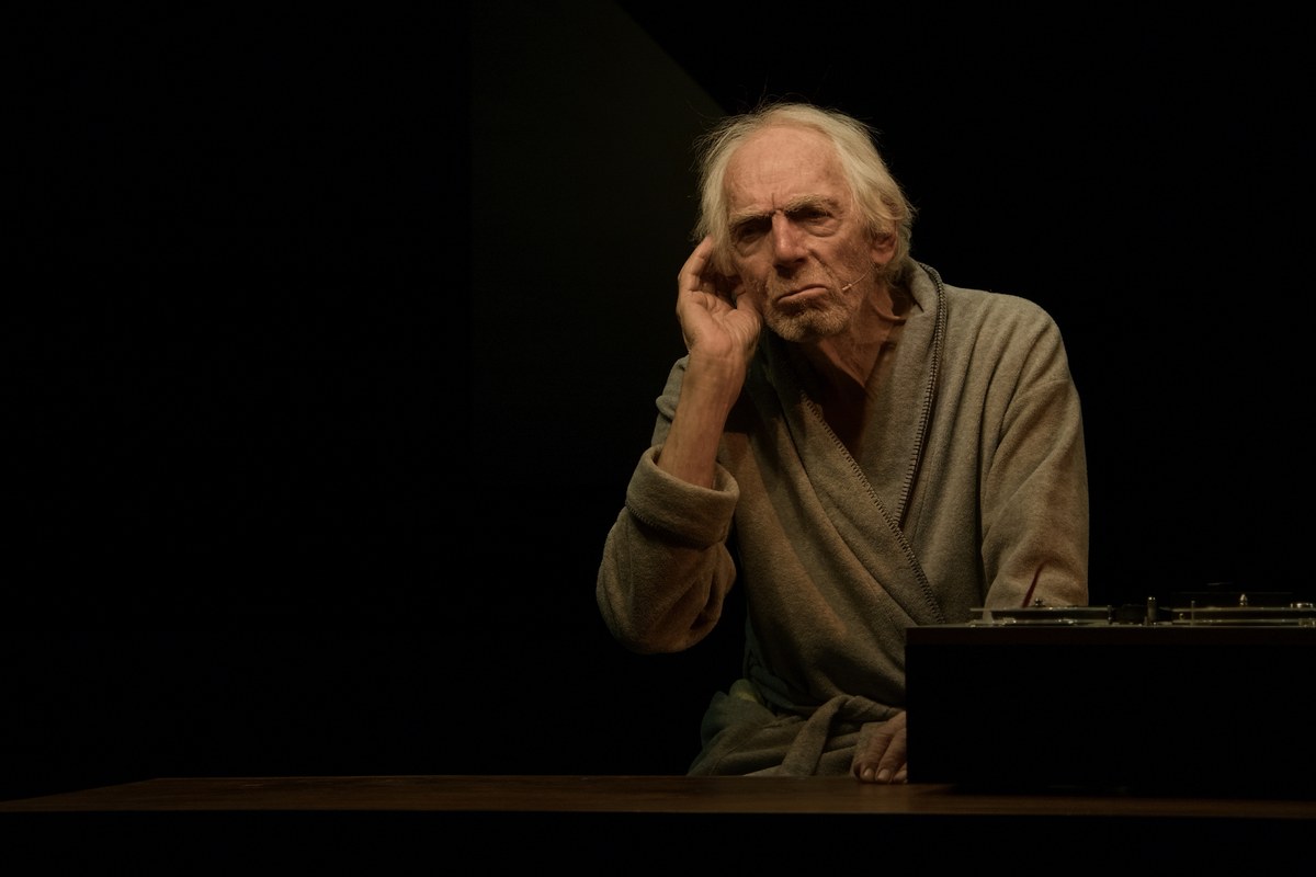 Peter Marinker as Krapp, a hand raised to his temple beside the reel-to-reel recorder, at The Cockpit