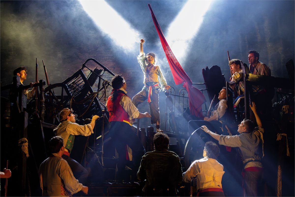 The company of Les Misérables at the barricade in Cameron Mackintosh’s West End production at the Sondheim Theatre. Photo by Danny Kaan