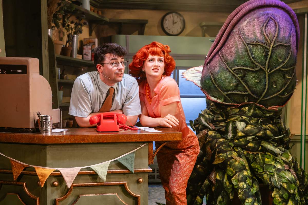 Jed Berry as Seymour and Maisie Smith as Audrey with Audrey II in Little Shop of Horrors at Hope Mill Theatre. Photo by Danny Kaan