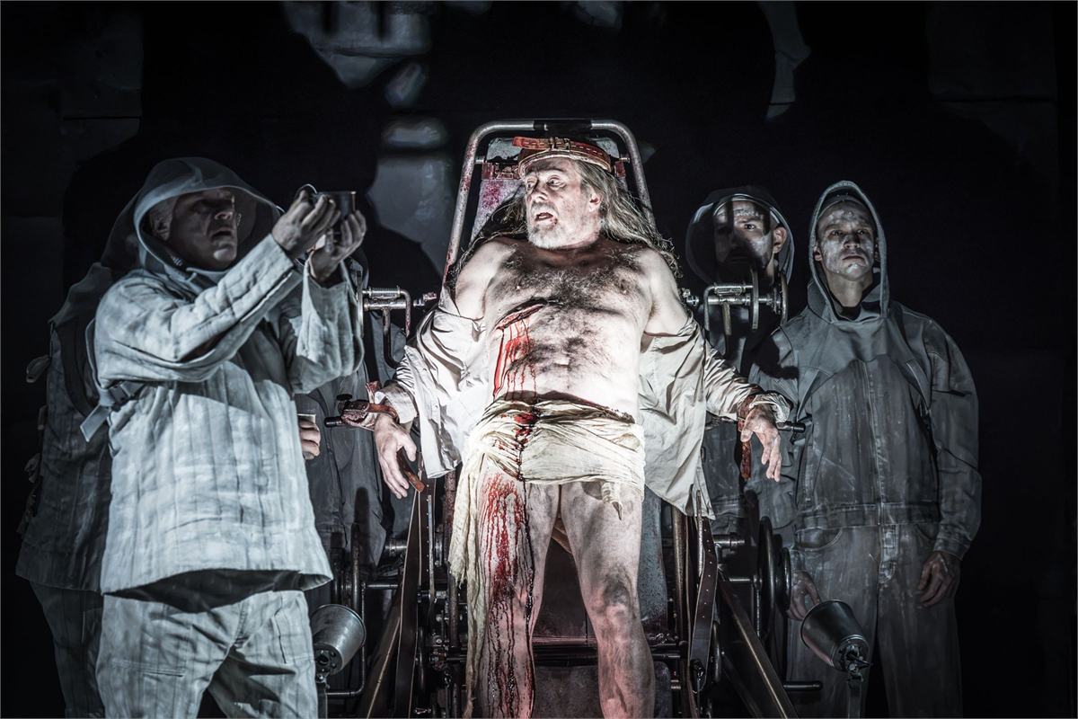 Christian Gerhaher as Amfortas among the hooded Grail Knights in Parsifal at the Royal Opera House. Photo by Marc Brenner