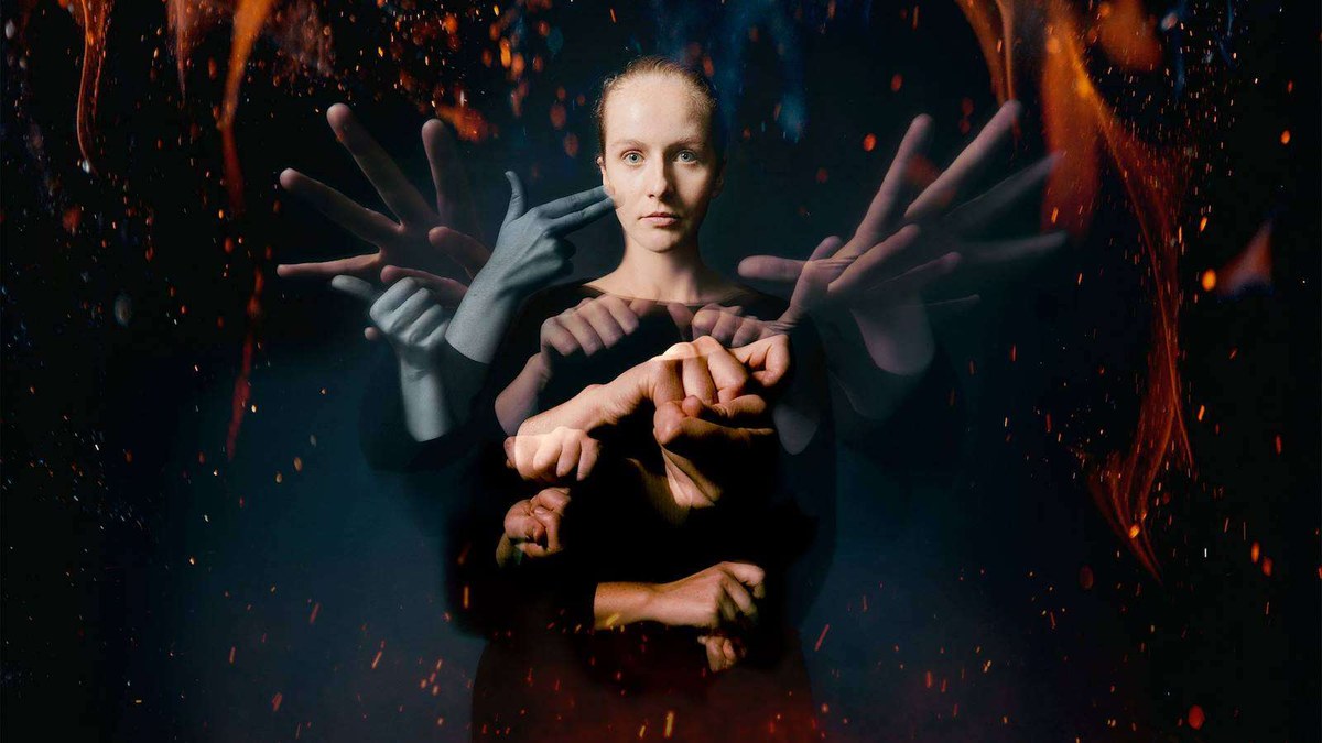 Artwork for The Quiet Revolution of Laurent Clerc at Park Theatre: a woman surrounded by signing hands against a background of embers
